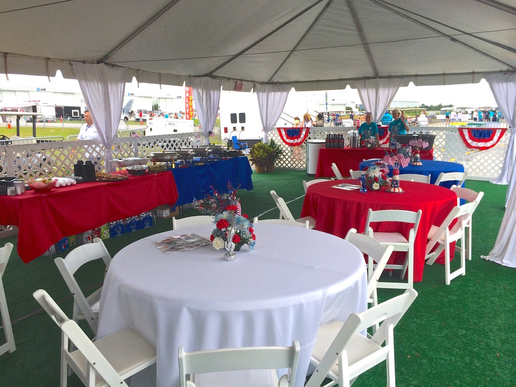 Air Show Chalet hospitality area with covered tables, seating, food service, and beverages